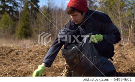 Man eco volunteer picking garbage 64994601