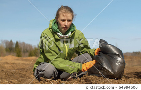 Woman eco volunteer picking trash 64994606