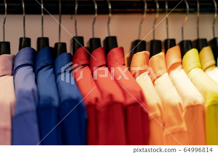 Close up of Multi colored shirts on hangers, 64996814