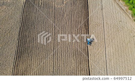 Top view of agricultural tractor vehicles working 64997512