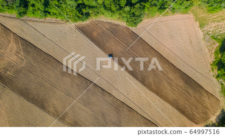 Top view of agricultural tractor vehicles working Top view of agricultural tractor vehicles working 64997516