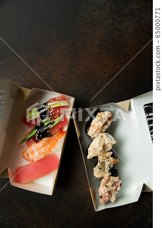 Beautiful gunkans and sushi for delivery on a dark background. Food delivery. Food at home. Delivery concept. Beautiful gunkans and sushi for delivery on a dark background. Food delivery. Food at home. Delivery concept. 65000771