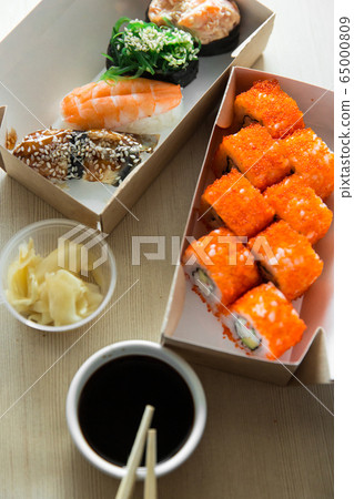 Beautiful rolls and sushi and california roll on a white table. Food delivery. Lunch. Food at home. Beautiful rolls and sushi and california roll on a white table. Food delivery. Lunch. Food at home. 65000809