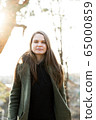 young beautiful woman in park posing for photographer 65000859