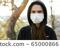 Close up of woman wearing protective face mask. Coronavirus covid-19 outbreak prevention concept. 65000866