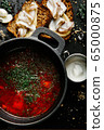 a traditional Ukrainian borsch made from beets, carrots, pork, potatoes, cabbage, herbs and garlic, close-up. 65000875