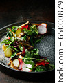 Healthy salad of fresh vegetables - tomatoes, avocado, arugula, radish and seeds on a bowl. Vegan food. Close up 65000879