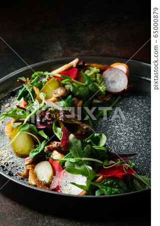 Healthy salad of fresh vegetables - tomatoes, avocado, arugula, radish and seeds on a bowl. Vegan food. Close up Healthy salad of fresh vegetables - tomatoes, avocado, arugula, radish and seeds on a bowl. Vegan food. Close up 65000879