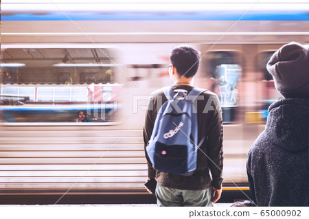 Back of a man waiting for the train under the sunlight at station in Melbourne, Australia. Back of a man waiting for the train under the sunlight at station in Melbourne, Australia. 65000902