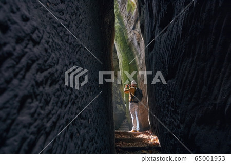 Photographer in the middle of rock formations Photographer in the middle of rock formations 65001953