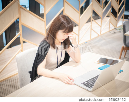 Woman whose eyes are tired from computer work 65002432