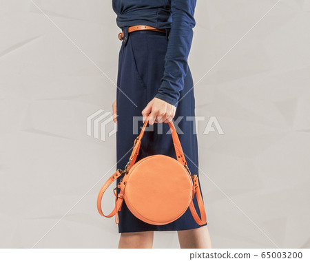 Stylish fashionable woman with orange round bag 65003200
