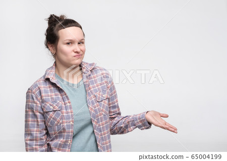 Young woman with disgusted expression showing on 65004199