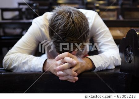 caucasian man praying in church. He has problems caucasian man praying in church. He has problems 65005218