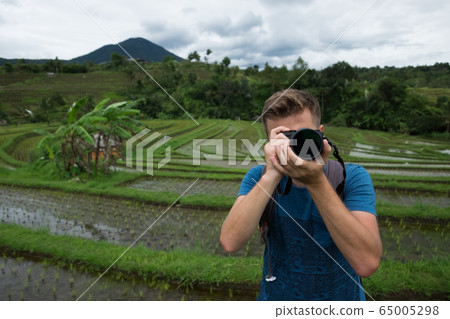 Young Man Traveler making photo and relaxing Young Man Traveler making photo and relaxing 65005298
