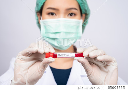 Young Asian doctor holding blood sample test tube Young Asian doctor holding blood sample test tube 65005335