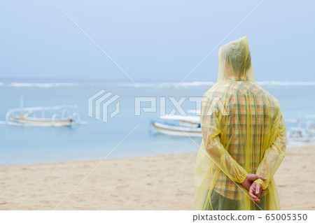 yellow raincoat on tropical seashore 