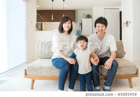 A family of three relaxing in the living room A family of three relaxing in the living room 65005459