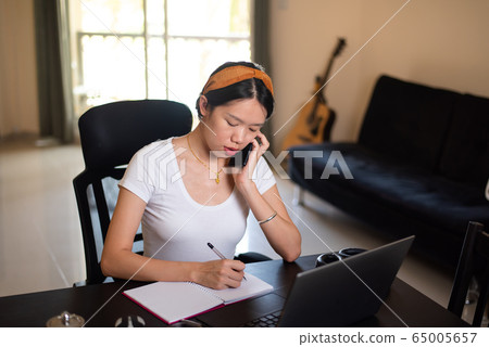 Busy woman on a phone meeting while working from 65005657