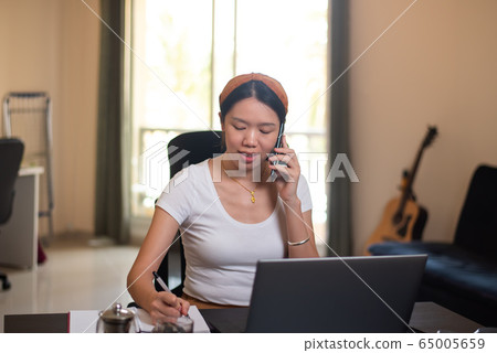 Busy woman on a phone meeting while working from 65005659