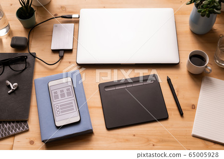 Mobile gadgets, pad with stylus, cup of coffee, notebooks, earphones, etc Mobile gadgets, pad with stylus, cup of coffee, notebooks, earphones, etc 65005928