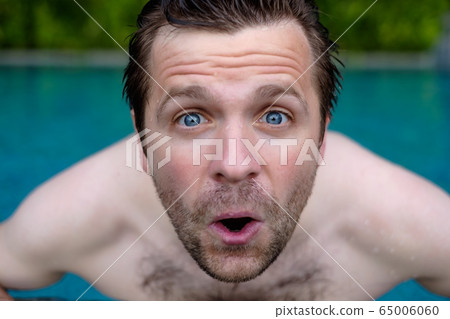 Man is shocked with news. He is closing his mouth. 65006060