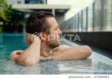 Content caucasian man in a swimming pool. 65006063