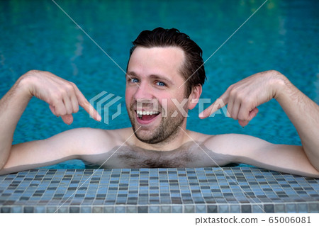 Proud caucasian young man looks forward showing Proud caucasian young man looks forward showing 65006081