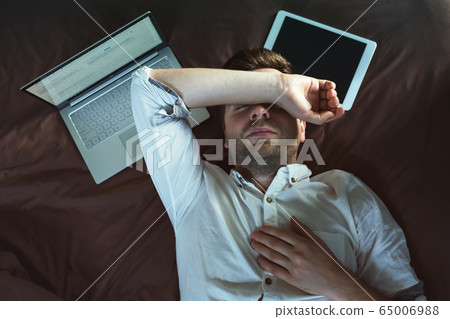 Tired caucasian young man in white shirt sleeping Tired caucasian young man in white shirt sleeping 65006988