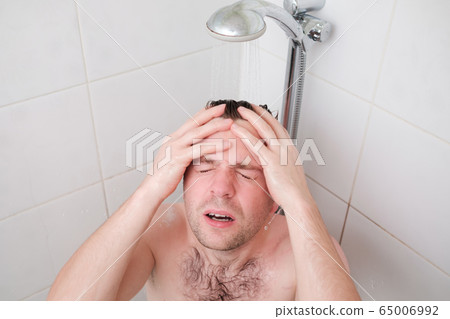 Man having a relaxing shower after hard day Man having a relaxing shower after hard day 65006992