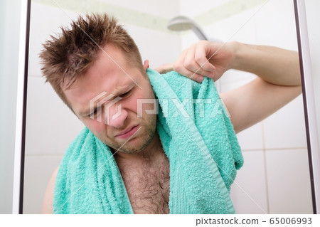 Young man cleaning his ear while taking a shower 65006993