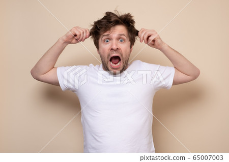 Hairy tired man on colored background. Guy does Hairy tired man on colored background. Guy does 65007003