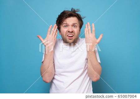 Hairy tired man on blue background. Guy does not Hairy tired man on blue background. Guy does not 65007004