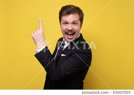 Positive caucasian business man pointing up finger Positive caucasian business man pointing up finger 65007005