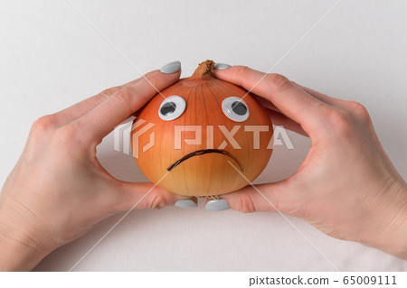 Female hands holding large Napiform onion with sad Female hands holding large Napiform onion with sad 65009111