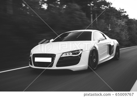 White cabriolet driving in the forest among oak trees,front view White cabriolet driving in the forest among oak trees,front view 65009767