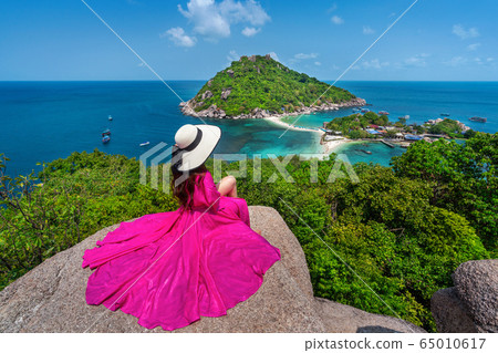 Beautiful girl sitting on viewpoint at Koh Nangyuan island near Koh Tao island, Surat Thaini in Thailand. 65010617