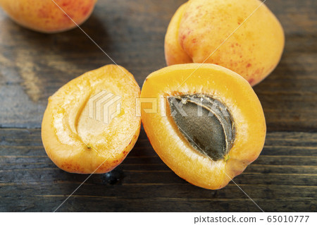 Ripe apricots on the wooden background. 65010777