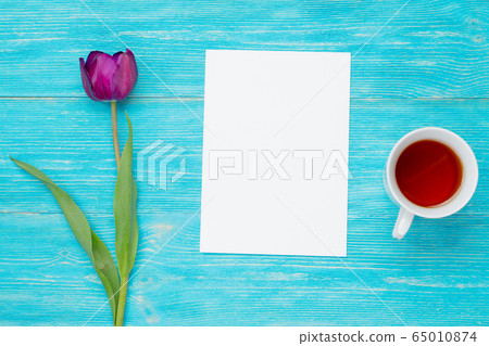 single tulip with empty paper sheet and tea cup single tulip with empty paper sheet and tea cup 65010874