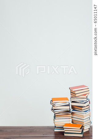 a lot of stacks of educational books for college exams in the library on a white background 65011147
