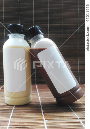 Baby bottles and cocoa bottles with empty labels Put it together on a woven wooden floor Baby bottles and cocoa bottles with empty labels Put it together on a woven wooden floor 65011936