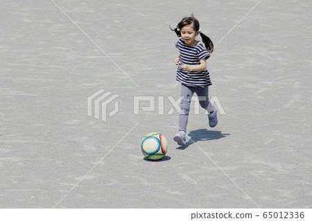 Toddler playing football dribbling (5 years old) 65012336