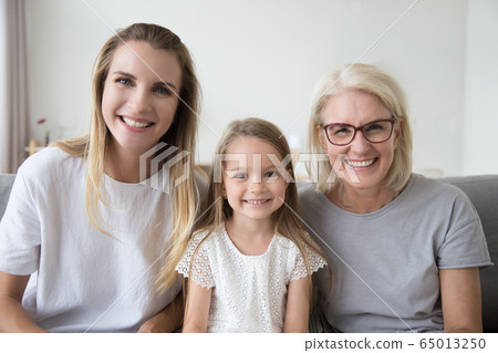 Happy old grandmother, smiling mother and child looking at camer 65013250
