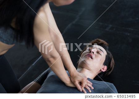 CPR or pump heart to young man in gym 65013495