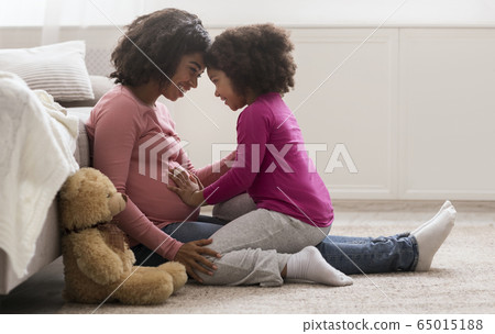 Happy Pregnant Black Woman And Her Cute Daughter Bonding At Home Happy Pregnant Black Woman And Her Cute Daughter Bonding At Home 65015188