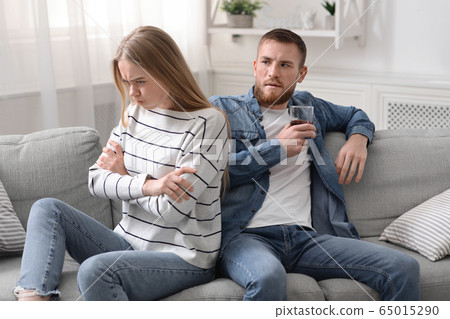 Angry woman offended at her drunk husband, ignoring him 65015290