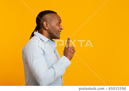 Mature african american man having idea, pointing finger up Mature african american man having idea, pointing finger up 65015598