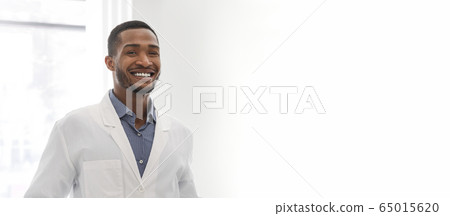 Portrait of young black dentist posing in clinic Portrait of young black dentist posing in clinic 65015620