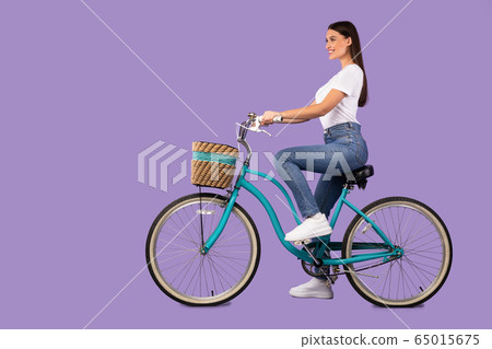 Beautiful woman riding her bike at studio, isolated 65015675