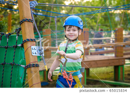 Little cute boy enjoying activity in a climbing 65015834